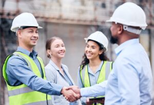 Construction workers and businesspeople shaking hands.